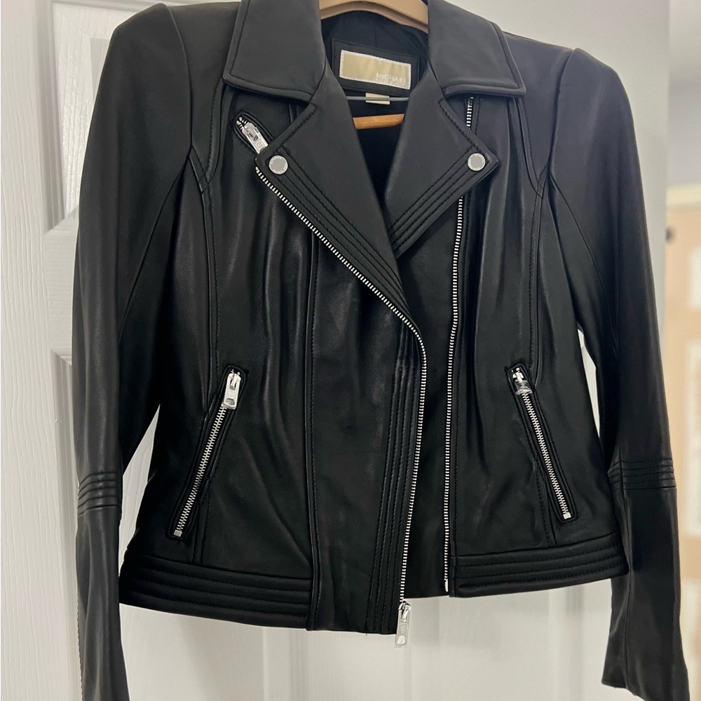 Smooth leather  asymmetric zipper and snap-fastened epaulettes.